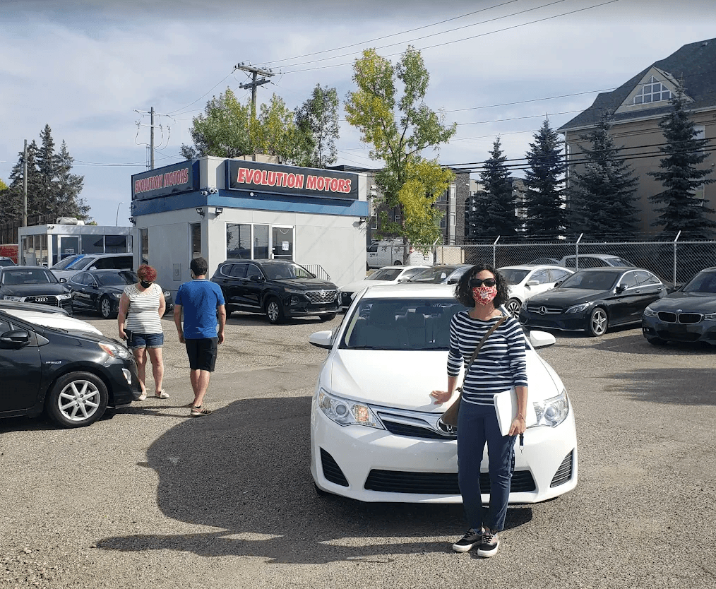 A happy customer at the Evolution Motors dealership lot in Calgary